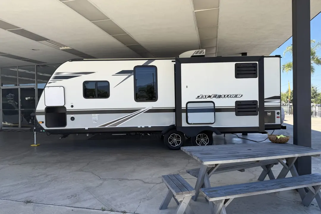 A 2021 Jayco Jay Feather travel trailer parked beside a picnic table