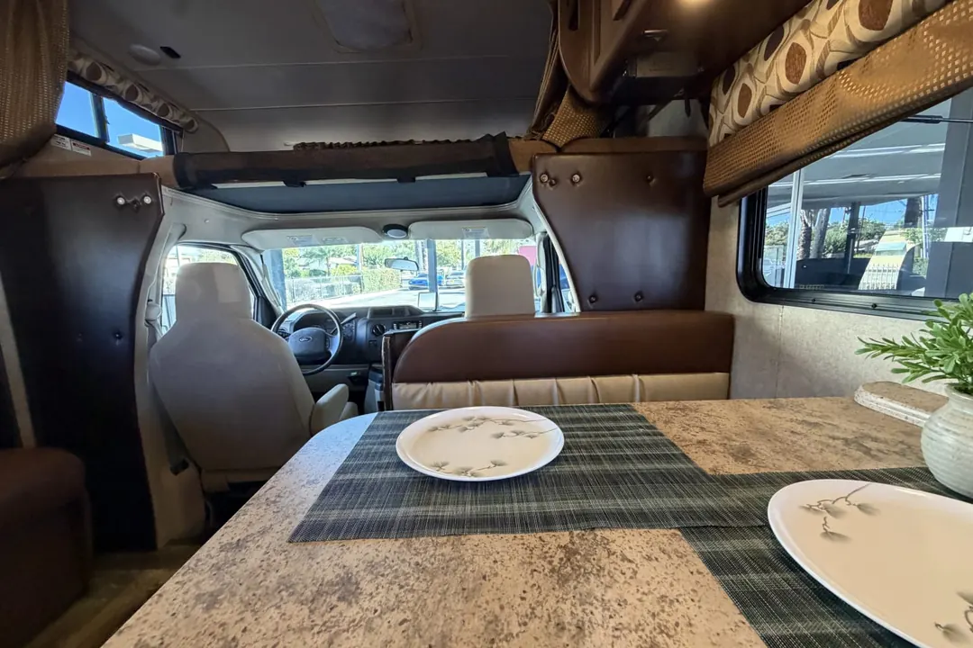 The dinette table set with plates in a 2017 Coachmen Leprechaun