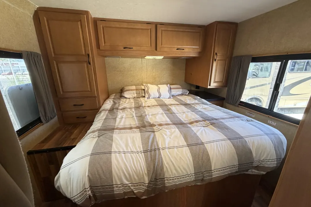 The made bed in the bedroom of a 2016 Forest River Majestic