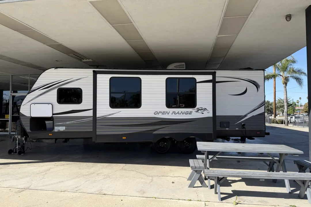 Side view of a 2021 Highland Ridge Open Range travel trailer beside a picnic table