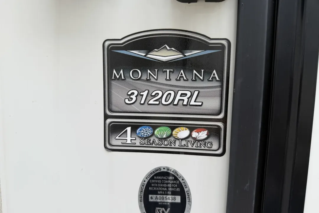 The Montana 3120RL model badge on the side of a Keystone fifth wheel