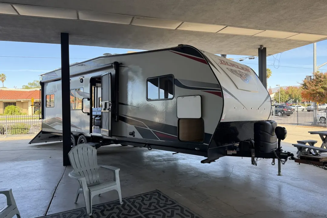 A 2022 Genesis Supreme Blazen toy hauler with its awning out