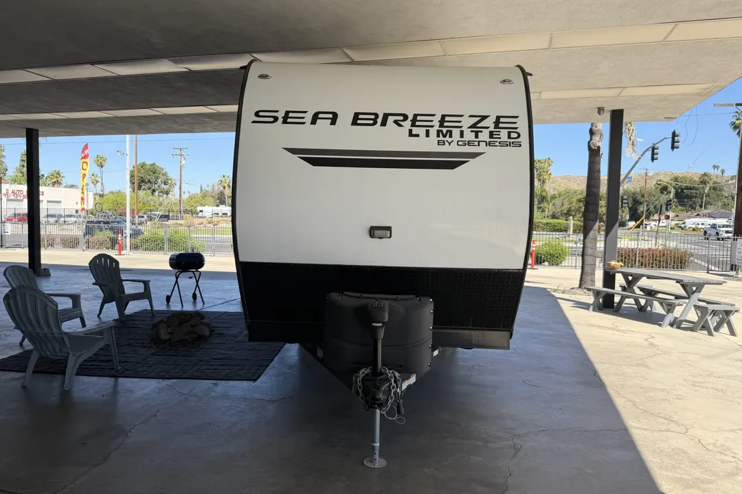 The front of a 2023 Genesis Supreme Sea Breeze travel trailer parked under cover