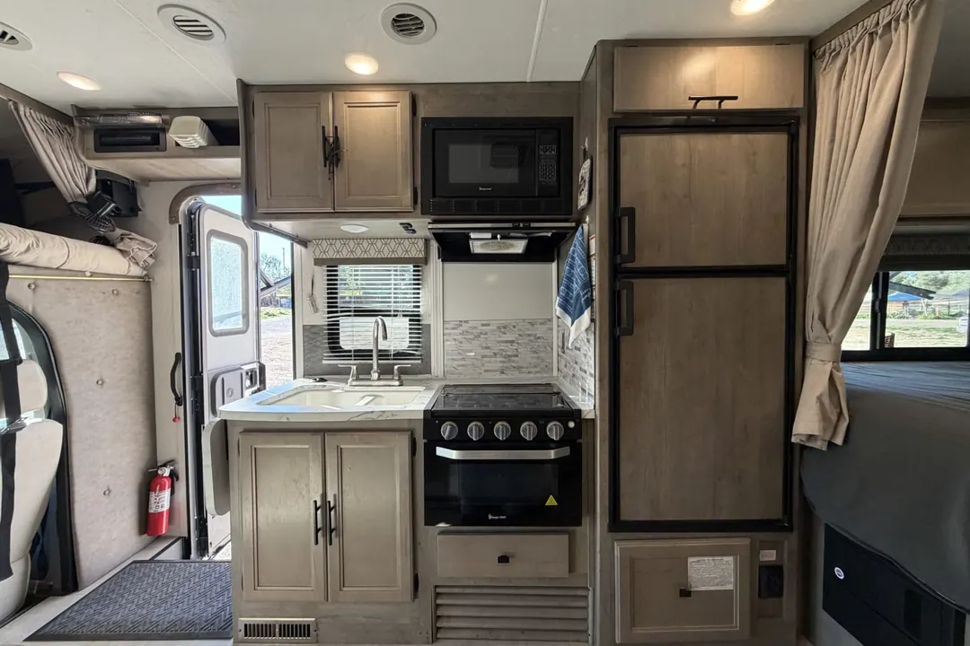 The galley in a 2020 Coachmen Prism with the stove, microwave and fridge