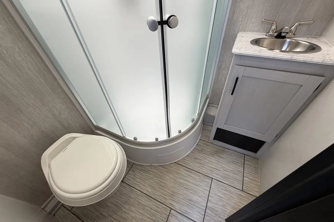 The corner shower, toilet and sink in a 2023 Genesis Supreme Sea Breeze
