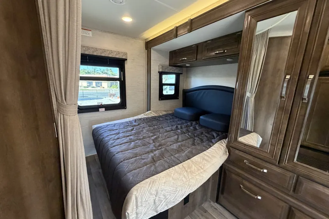 A made bed with pillows in the bedroom of a 2021 Jayco Melbourne