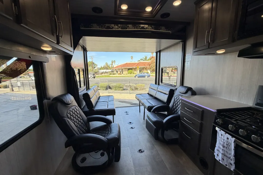 Recliners and the kitchen inside a 2022 Genesis Supreme Blazen toy hauler