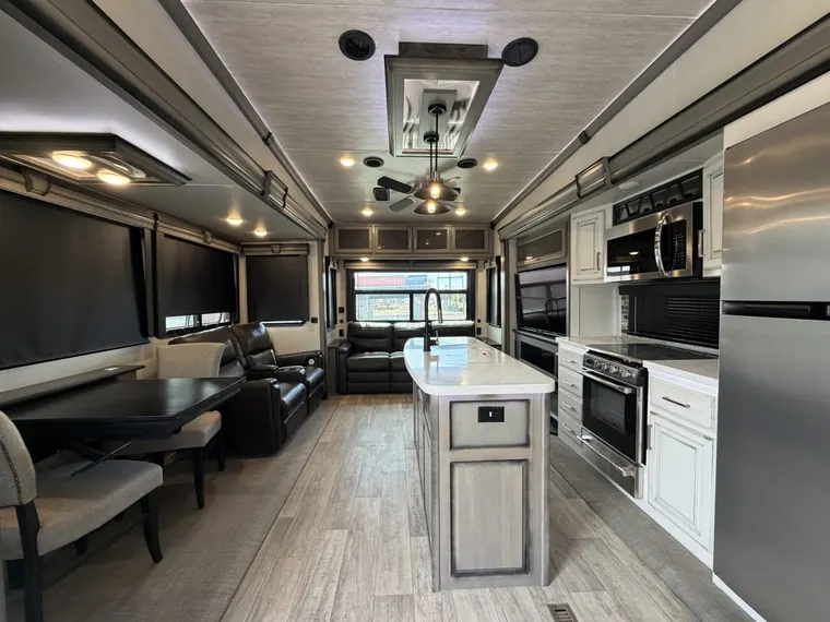 Inside a 2021 Keystone Montana 3120RL fifth wheel: kitchen island, dinette and theater seats